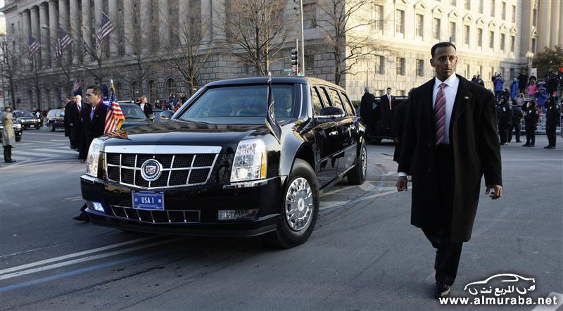 U.S. Secret Service officers escort the presidential limousine down Pennsylvania Avenue enroute to the White House