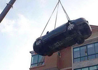 “بالصور” امرأة صينية ترفع سيارة أودي يمكلها ابن زوجها الى سطح منزلها لانه لم يسدد دينها!