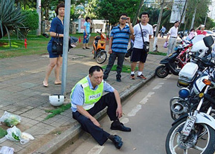 “بالصور” امرأة صينية غاضبة تعتدي على شرطي بالضرب المبرح بعد تحريره المخالفة